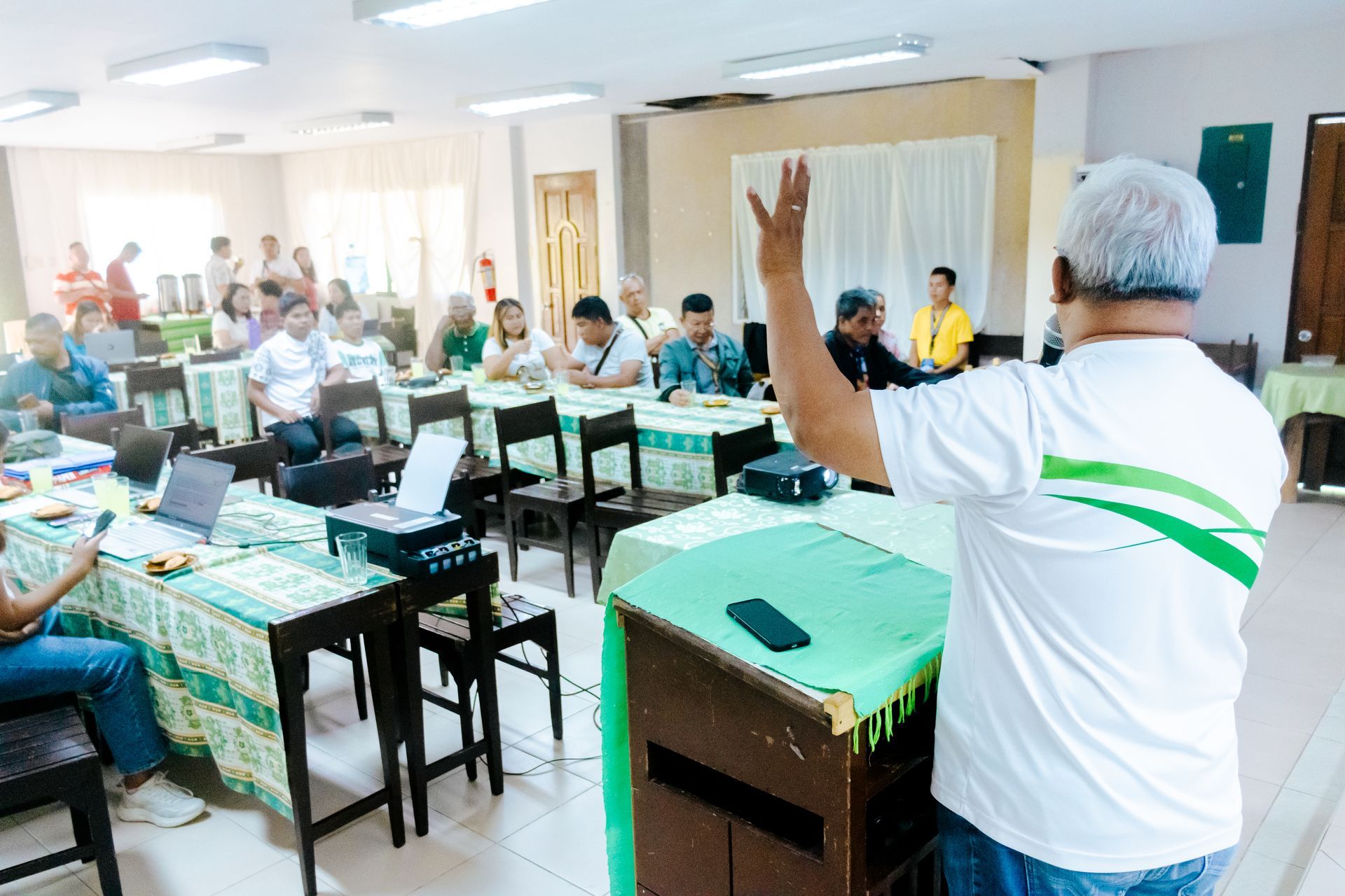 A speaker presents to local stakeholders in a classroom setting as part of a Project Caraga capacity-building workshop.