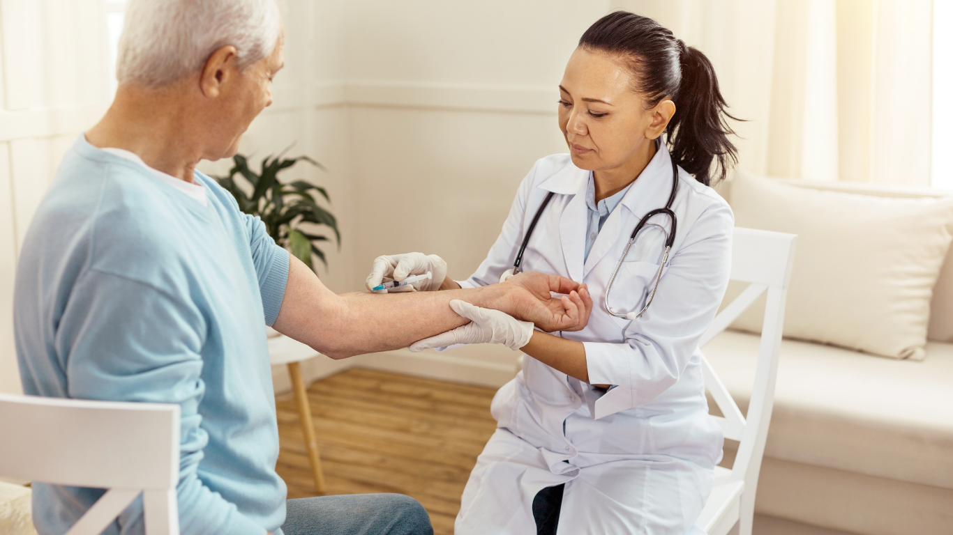 A medical professional in a white coat examines the wrist of a patient in a light room.