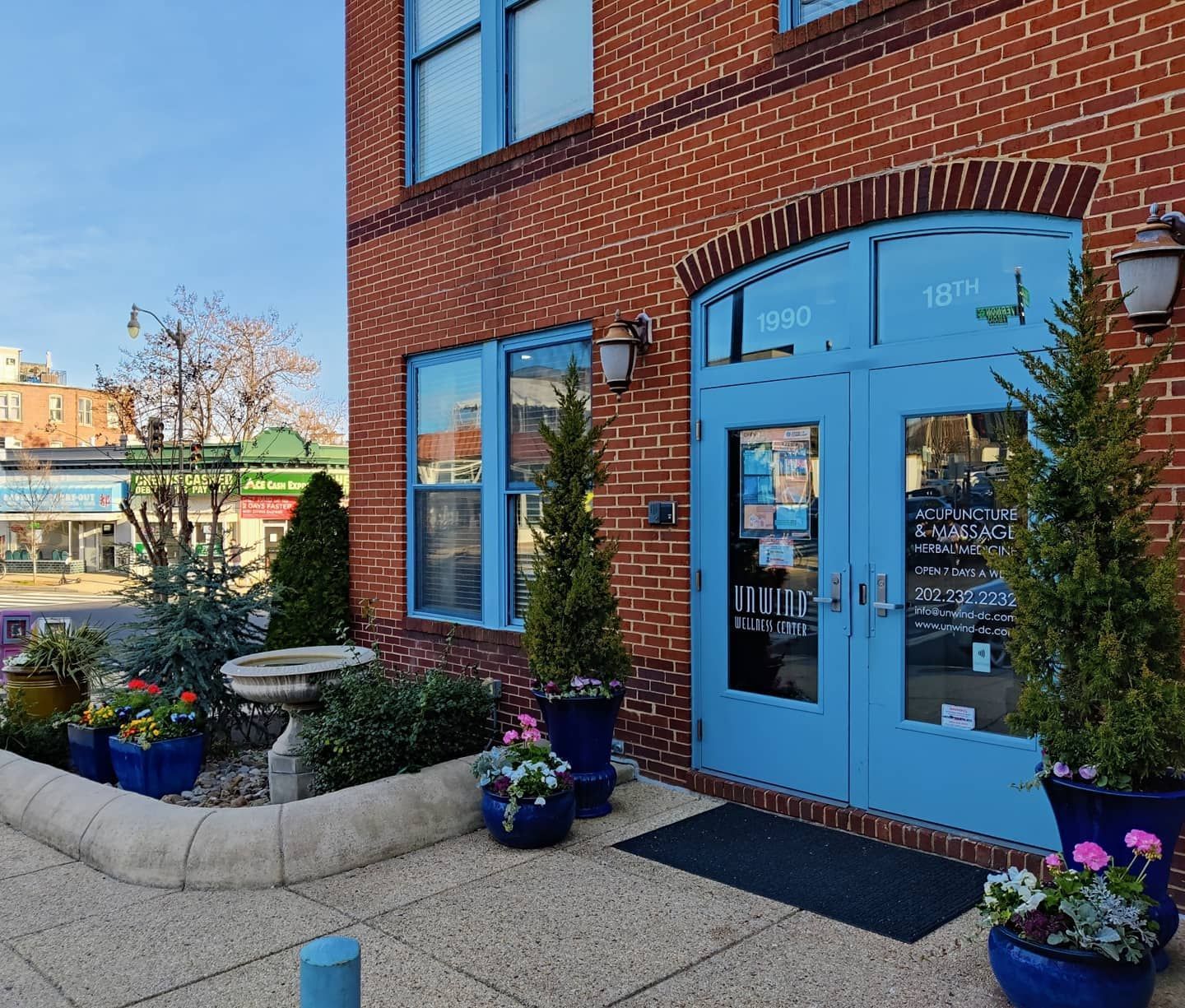 A brick storefront with bright blue doors and window frames.