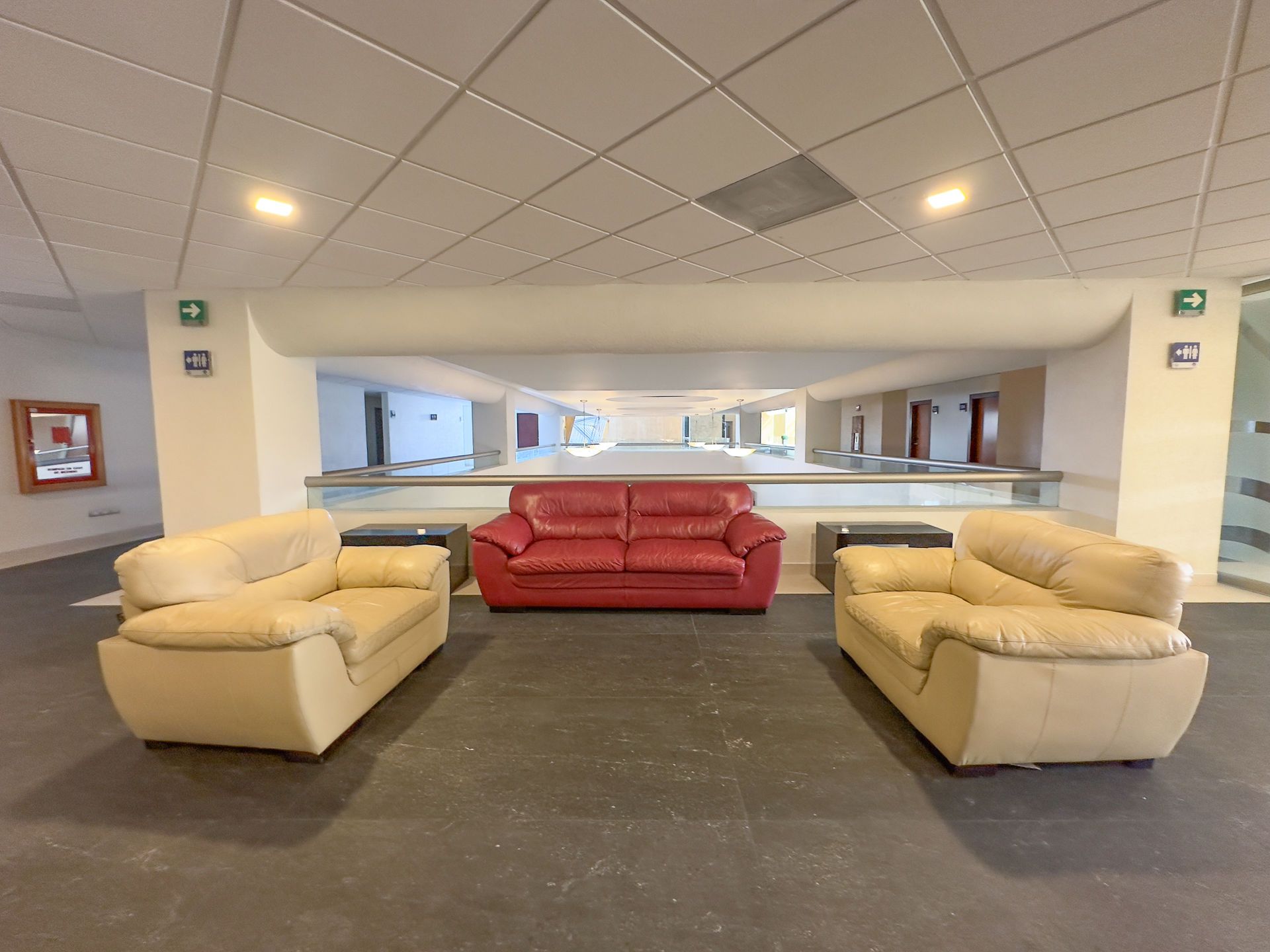 Un vestíbulo con un sofá de cuero rojo situado en el centro