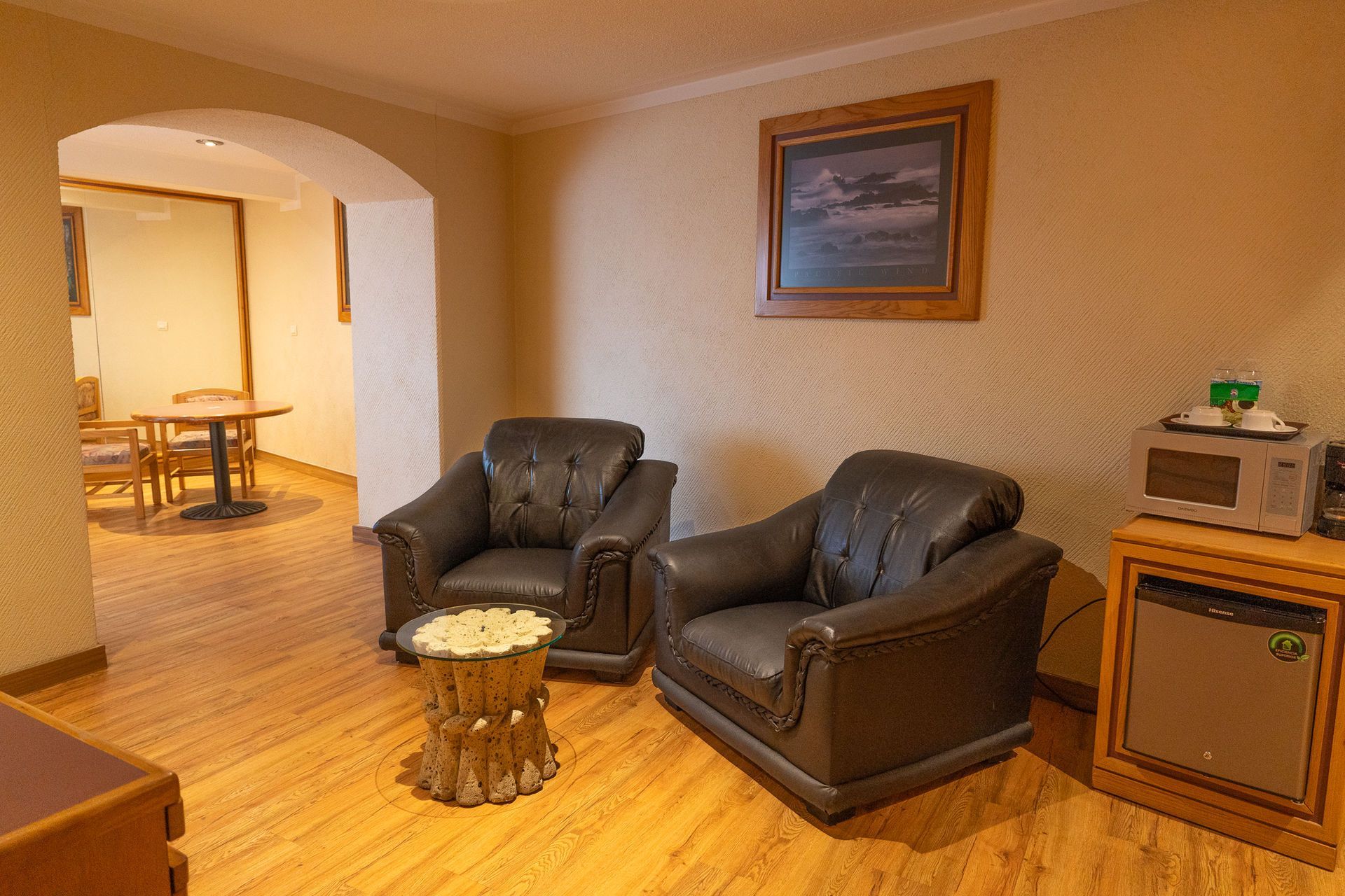 Una sala de estar de hotel con dos sillones de cuero oscuro,