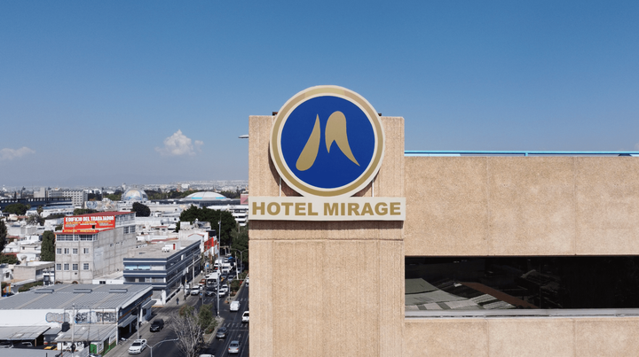 La fachada de un edificio de color beige, con un logotipo de HOTEL MIRAGE