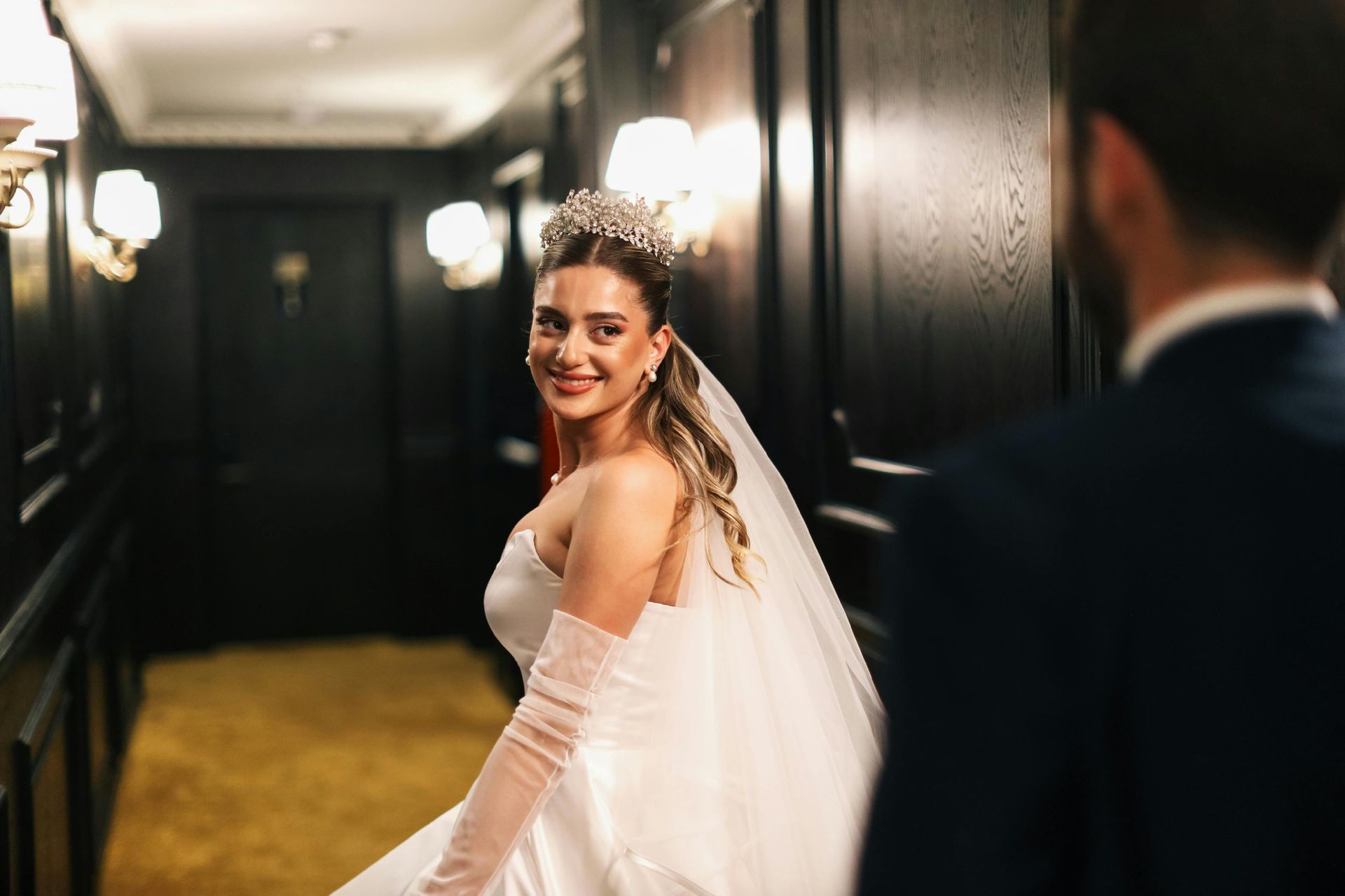 Una novia sonriente, vestida con un vestido de novia blanco 