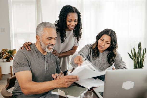 A woman is sitting at a table talking to a man and a woman.