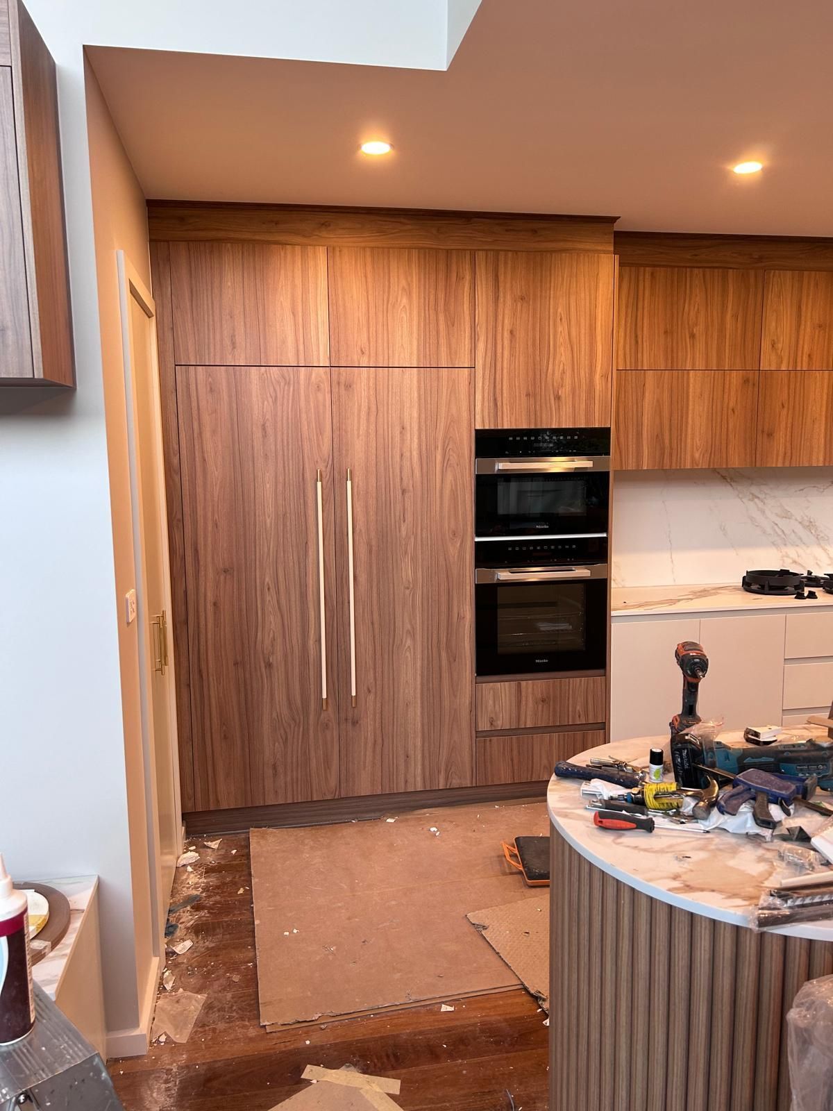 A kitchen with wooden cabinets and stainless steel appliances is being remodeled.