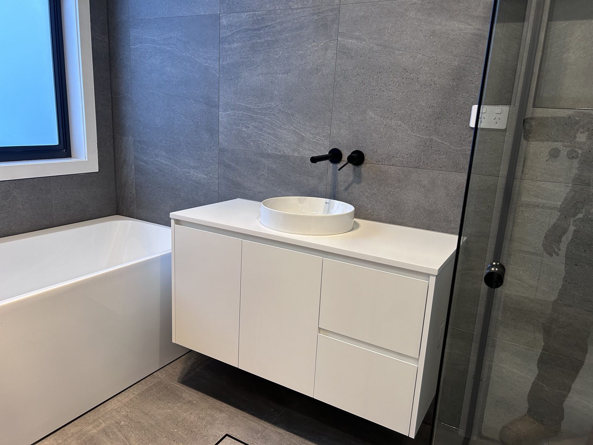A bathroom with a sink , bathtub and shower.