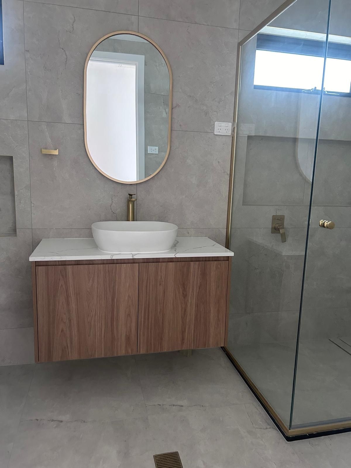 A bathroom with a sink , mirror and shower.