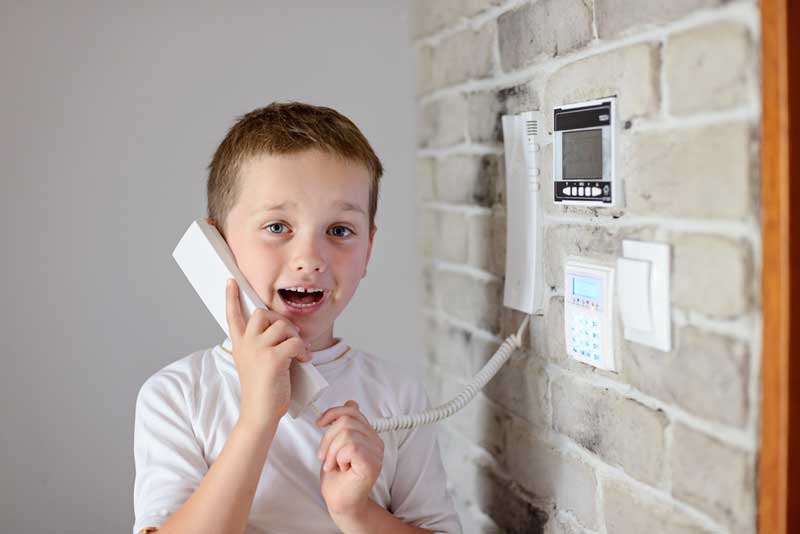 Kid Holding Phone — Home security systems Sunshine Coast in Tewantin, QLD