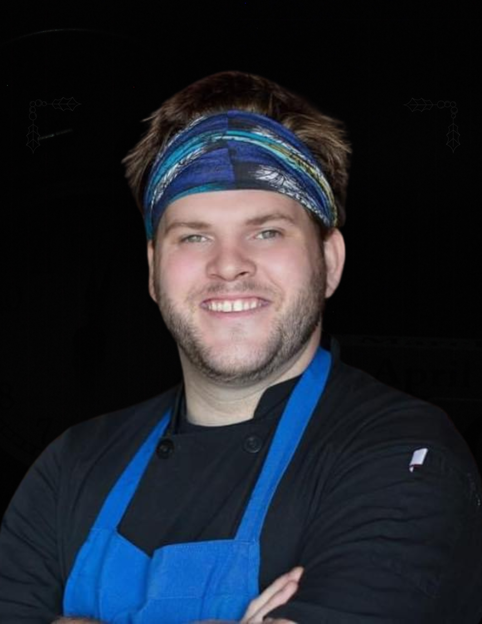 A man wearing a headband and an apron is smiling for the camera.