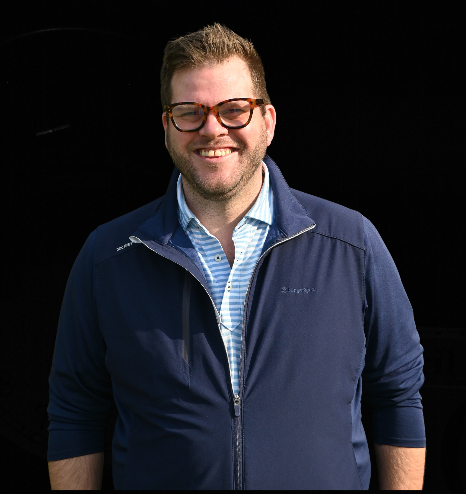 A man wearing a headband and an apron is smiling for the camera.