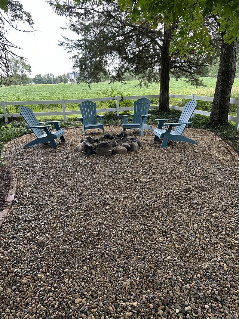 A group of chairs are sitting around a fire pit.