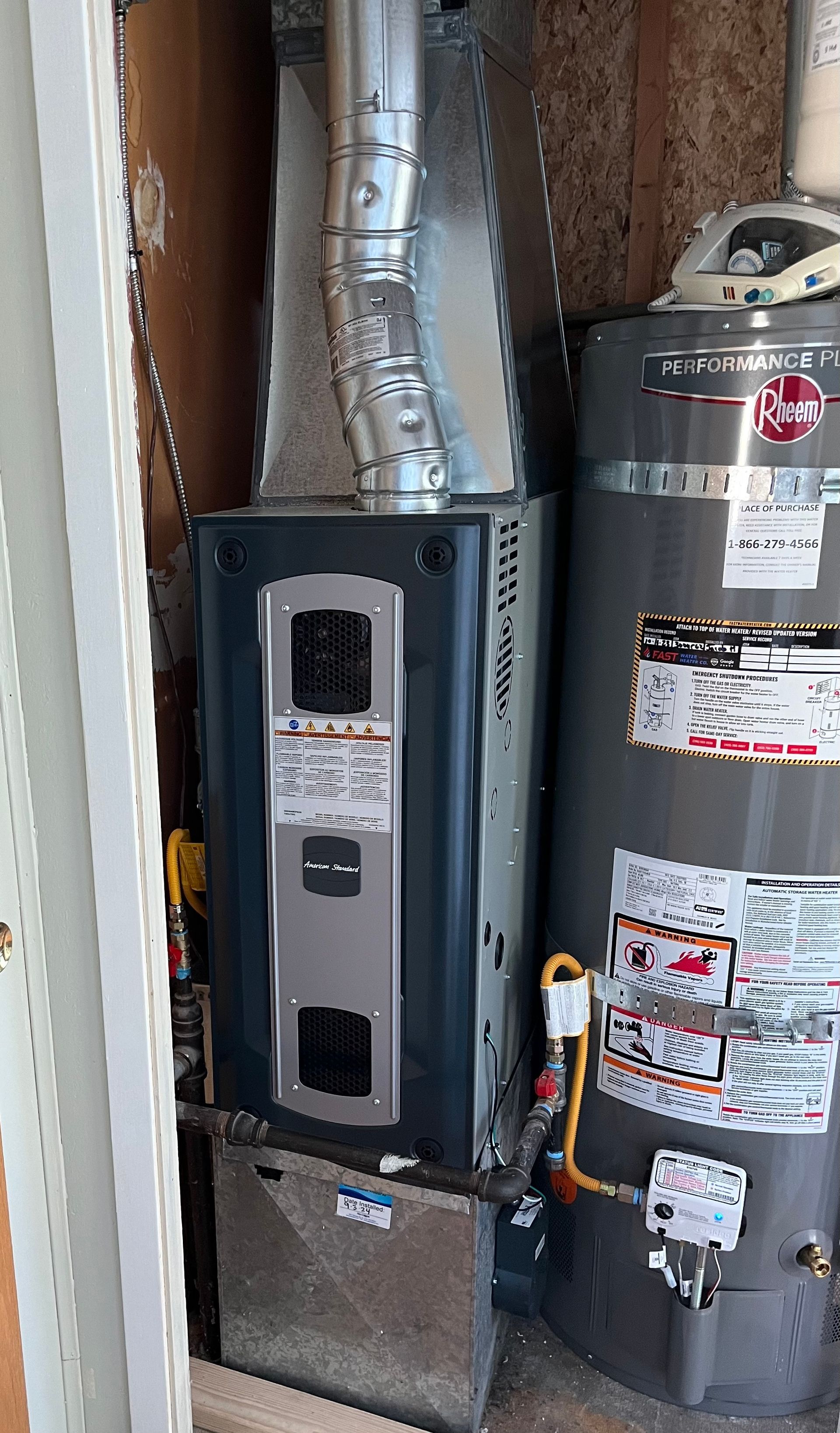 A heater and a water heater are sitting next to each other in a room.