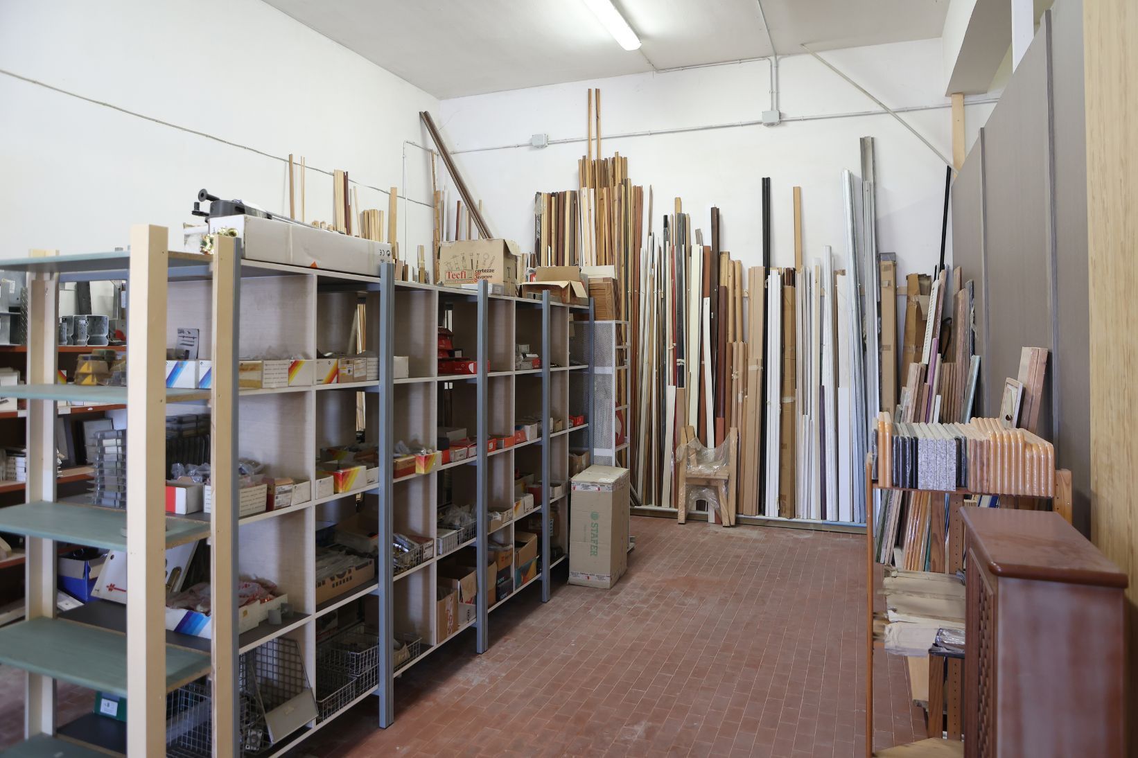 Un uomo con una camicia a quadri tiene in mano un elettroutensile giallo in una falegnameria