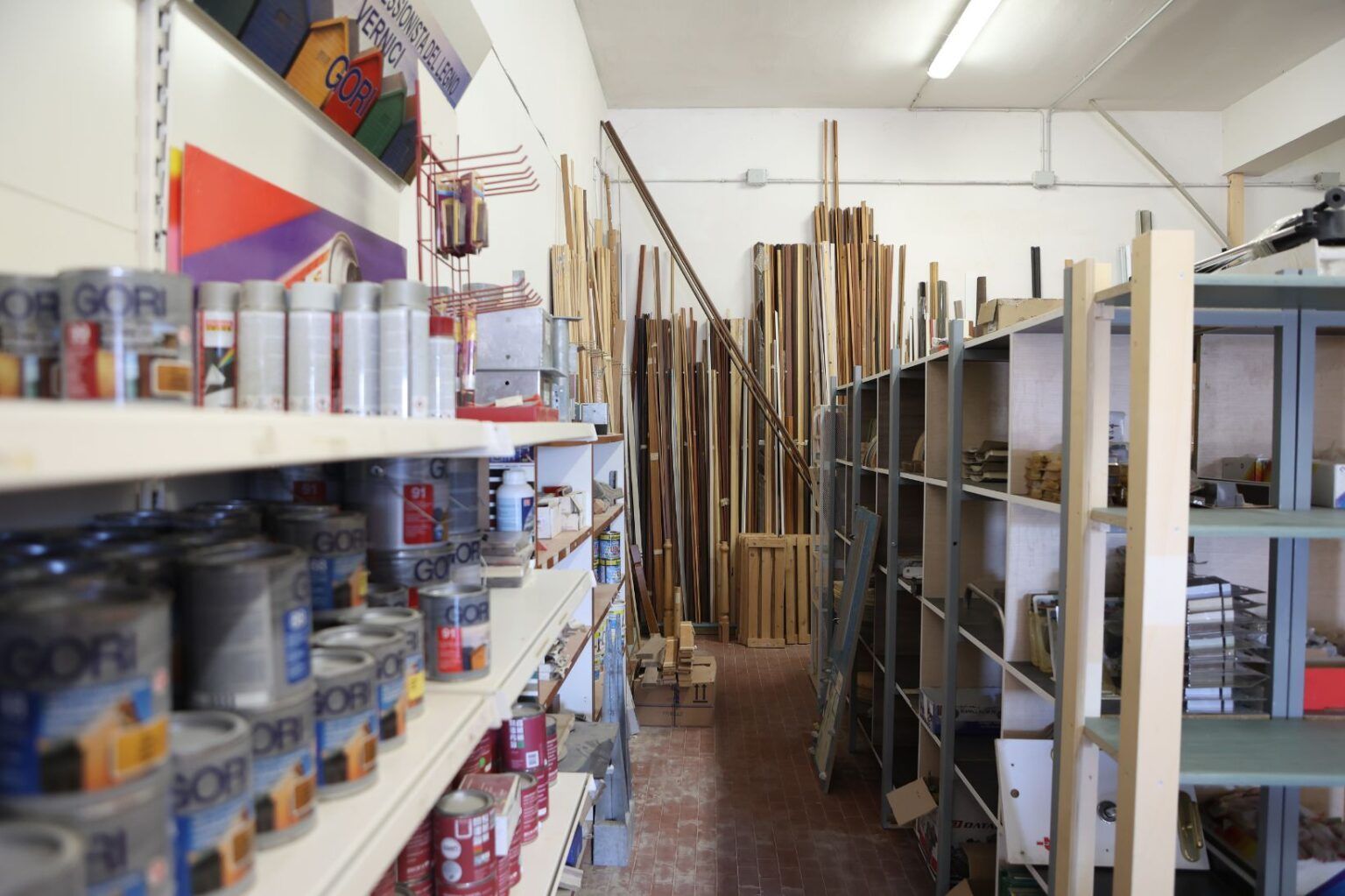 Un falegname pianta un chiodo in una tavola di legno; dettaglio ripreso con la cintura portautensili.