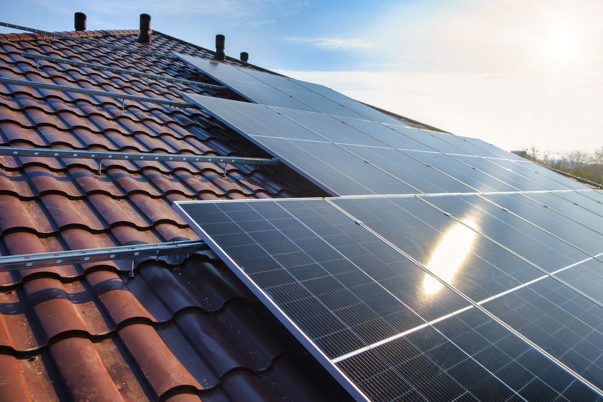 A row of solar panels on a tiled roof