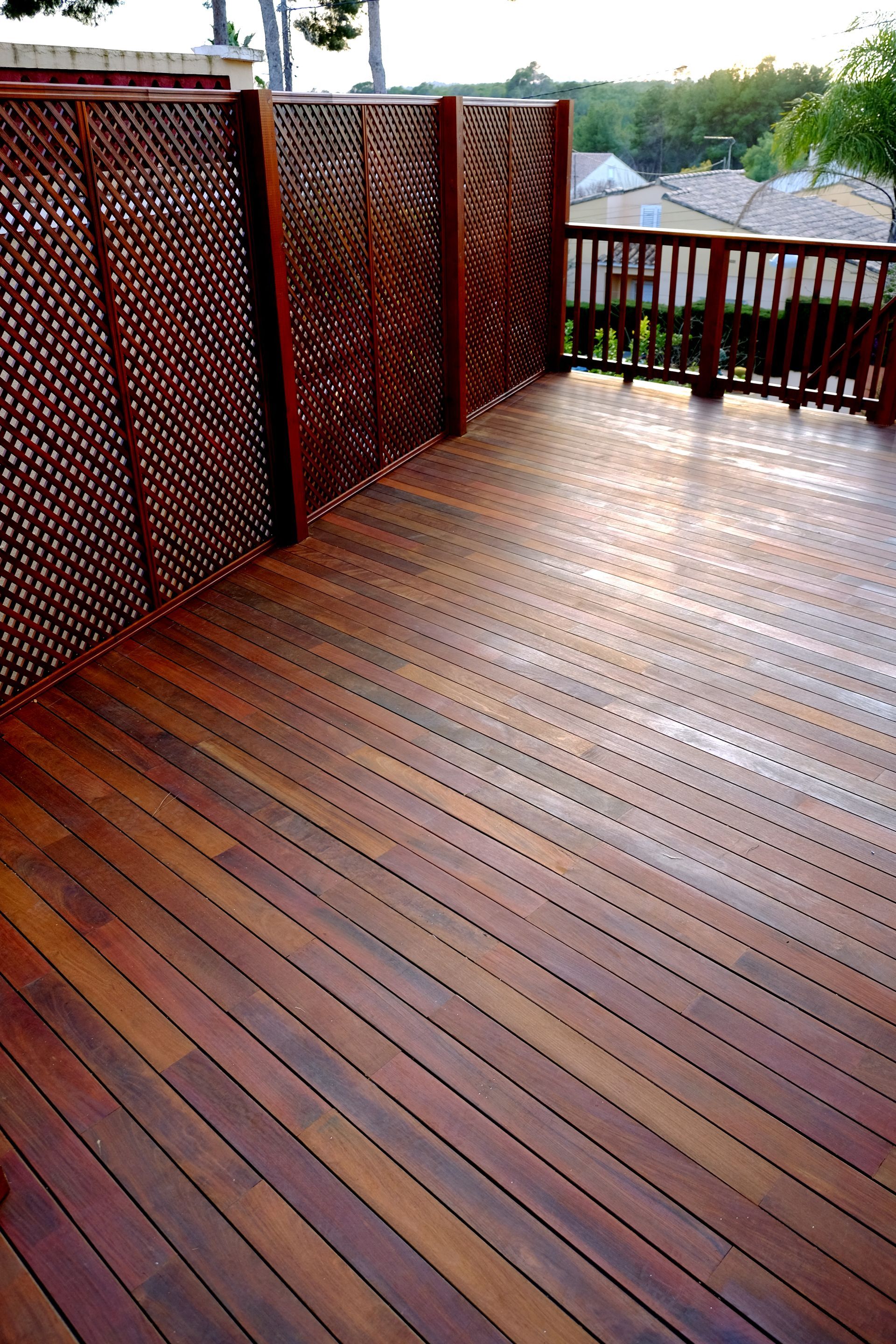 A wooden deck with a fence in the background