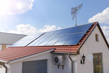 A house with solar panels on the roof and an antenna on top.