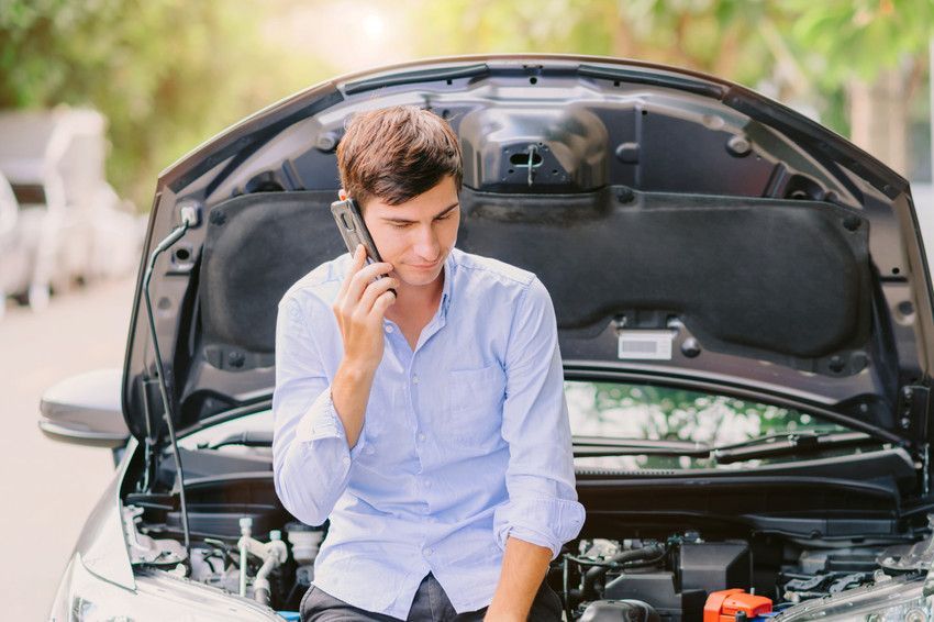 man with broken down car