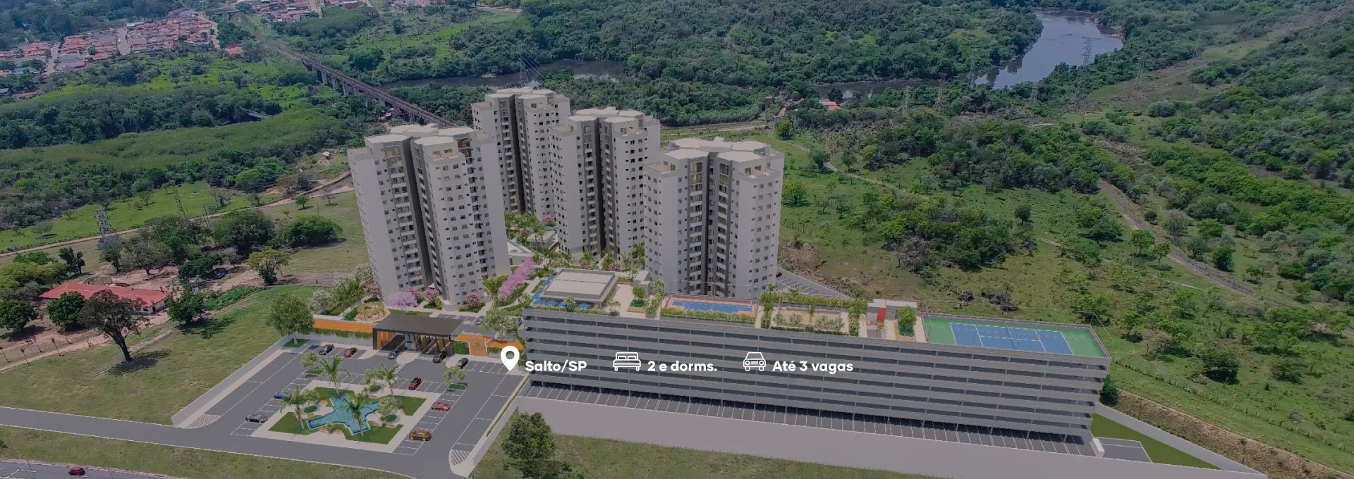 Vista aérea de prédios de apartamentos e estacionamento ao lado de uma área florestal e um rio.