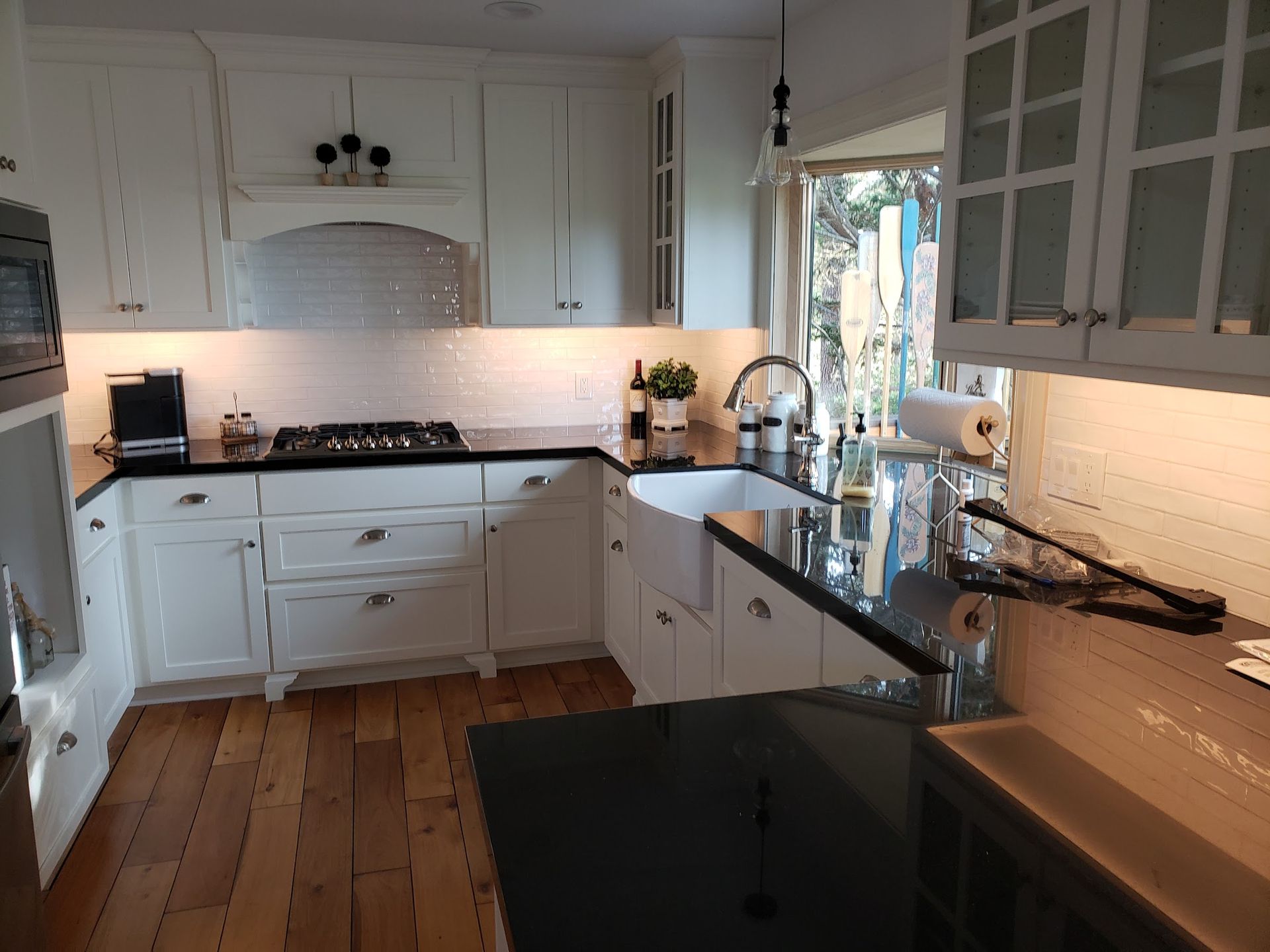 A kitchen with white cabinets and black counter tops