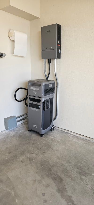 A vacuum cleaner is sitting in a garage next to a wall.