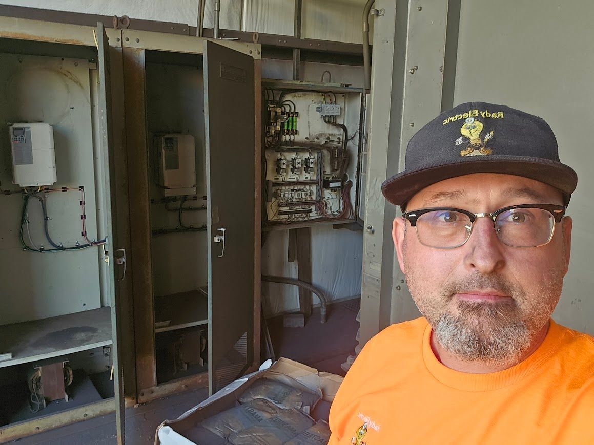 A man wearing a hat and glasses is standing in a room.