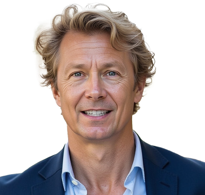 A middle-aged man with blonde hair smiles. He wears a blue blazer over a light blue shirt and jeans, hands in pockets.