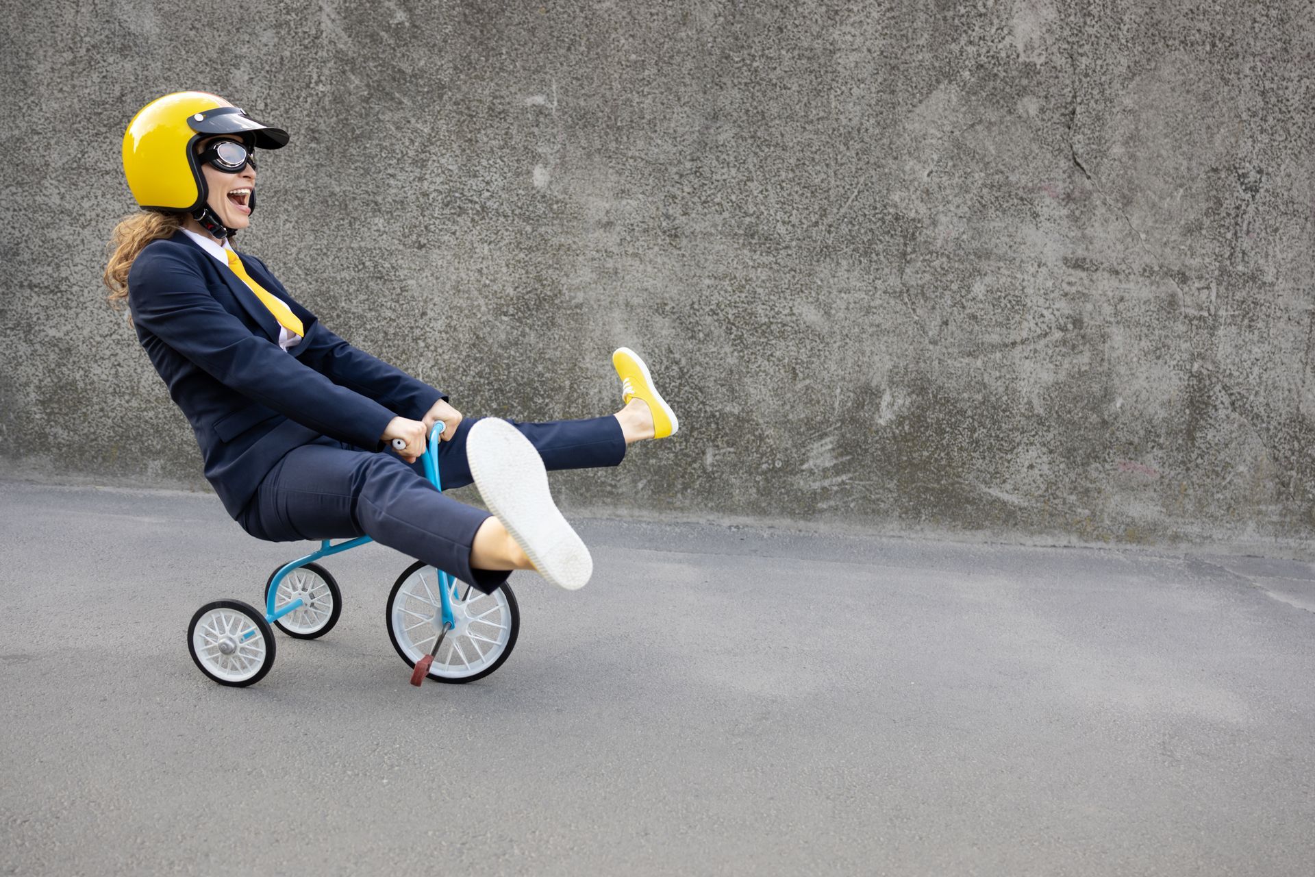 grown woman on children's trike scooting downhill