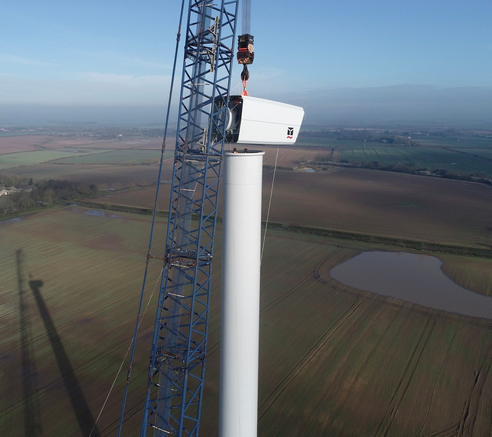 An aerial view of a wind turbine being built in a field
