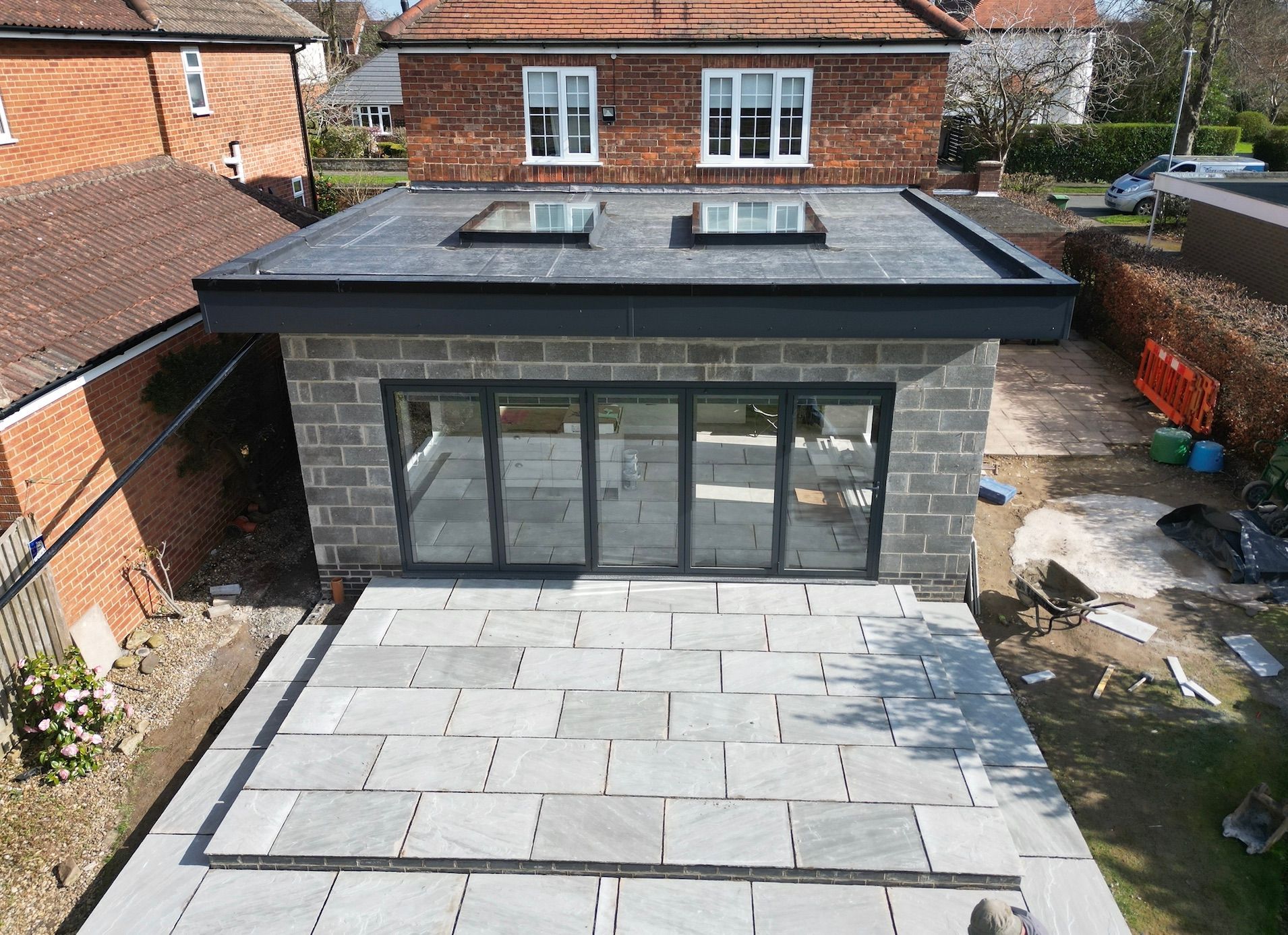 An aerial view of a brick house with a patio in front of it.