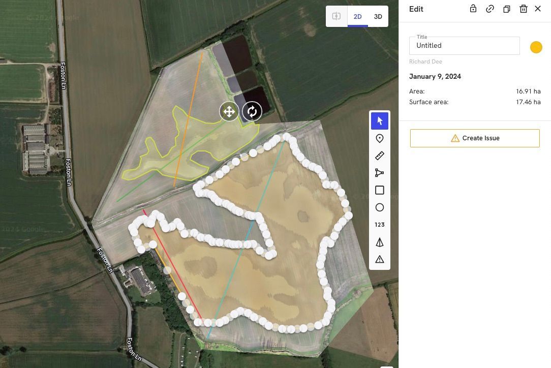 An aerial view of a field with a white line going through it.