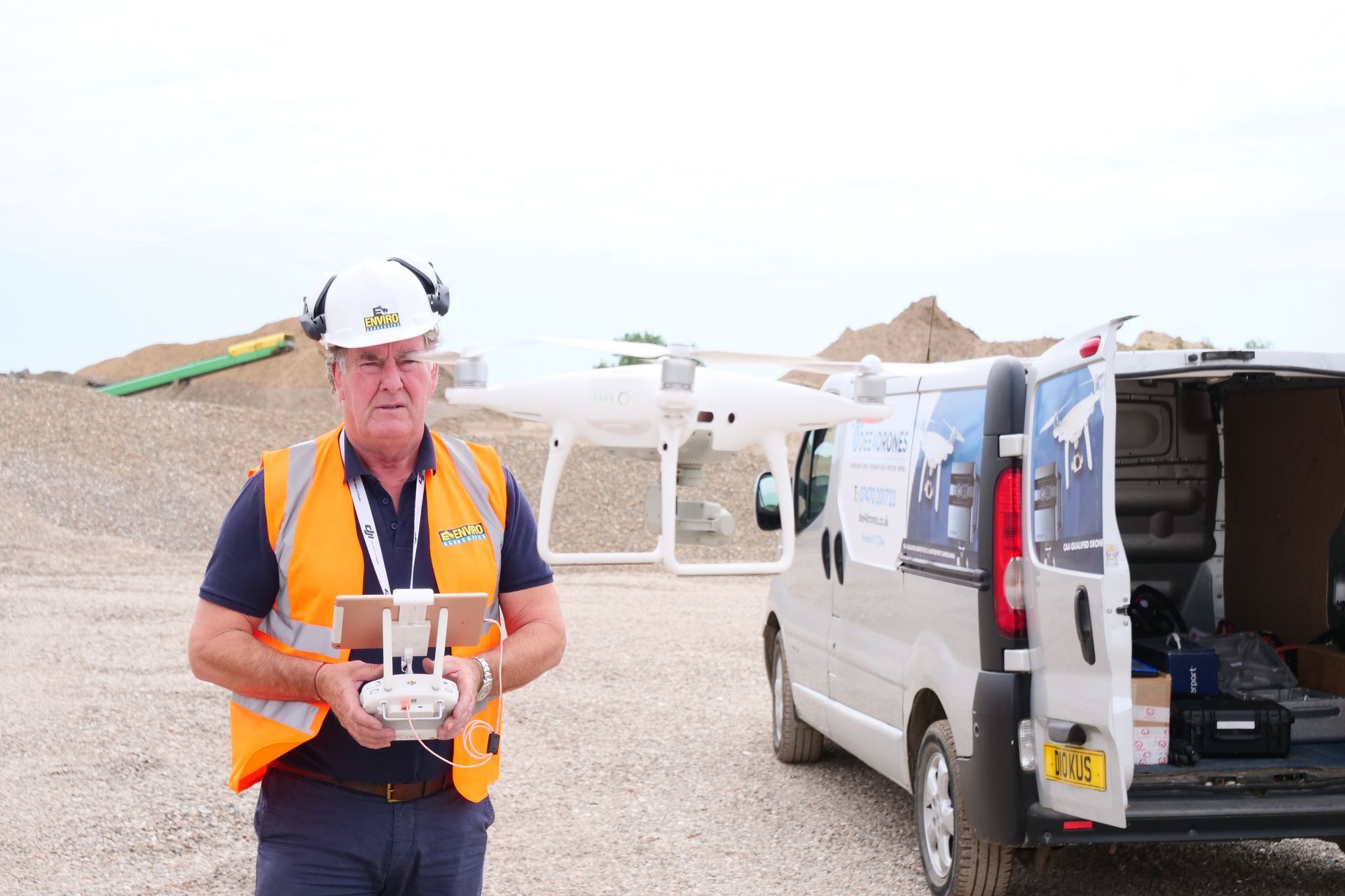 A man is holding a remote control in front of a van.