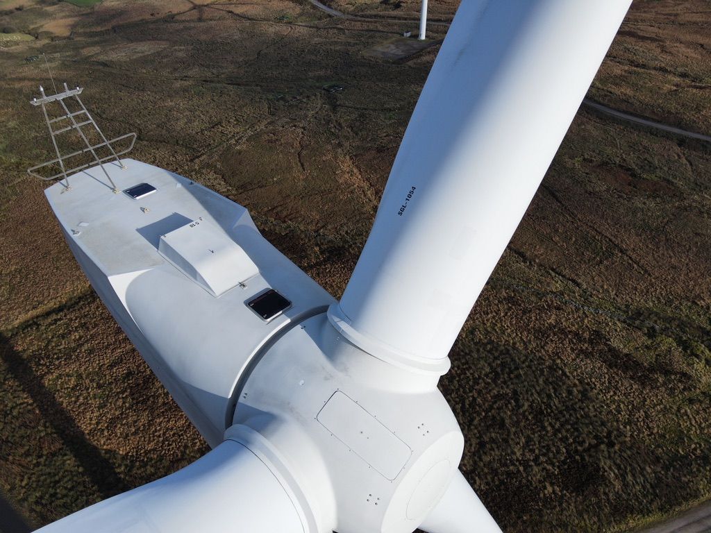 An aerial view of a wind turbine in a field