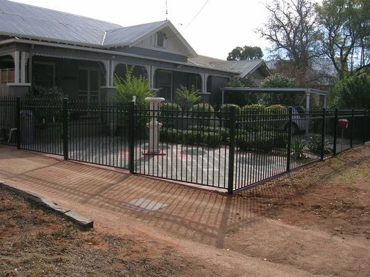 A fence surrounds a patio in front of a house