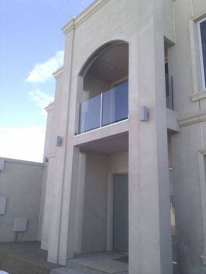 A large white building with a balcony and a door