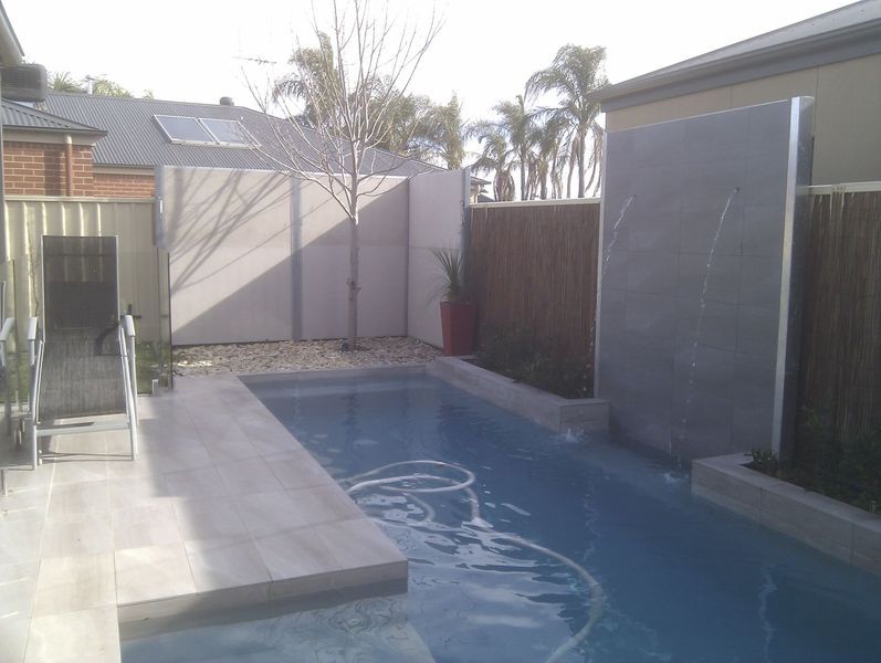 A large swimming pool in the backyard of a house