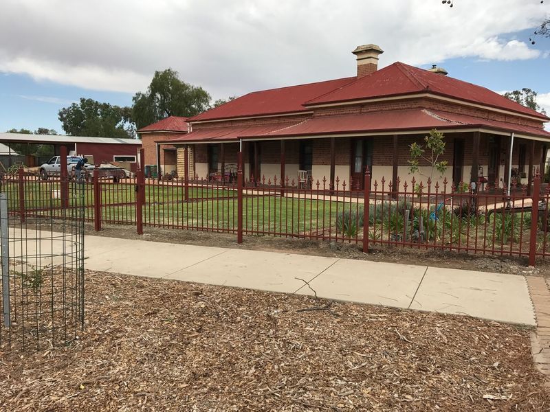 A large house with a red roof and a fence around it