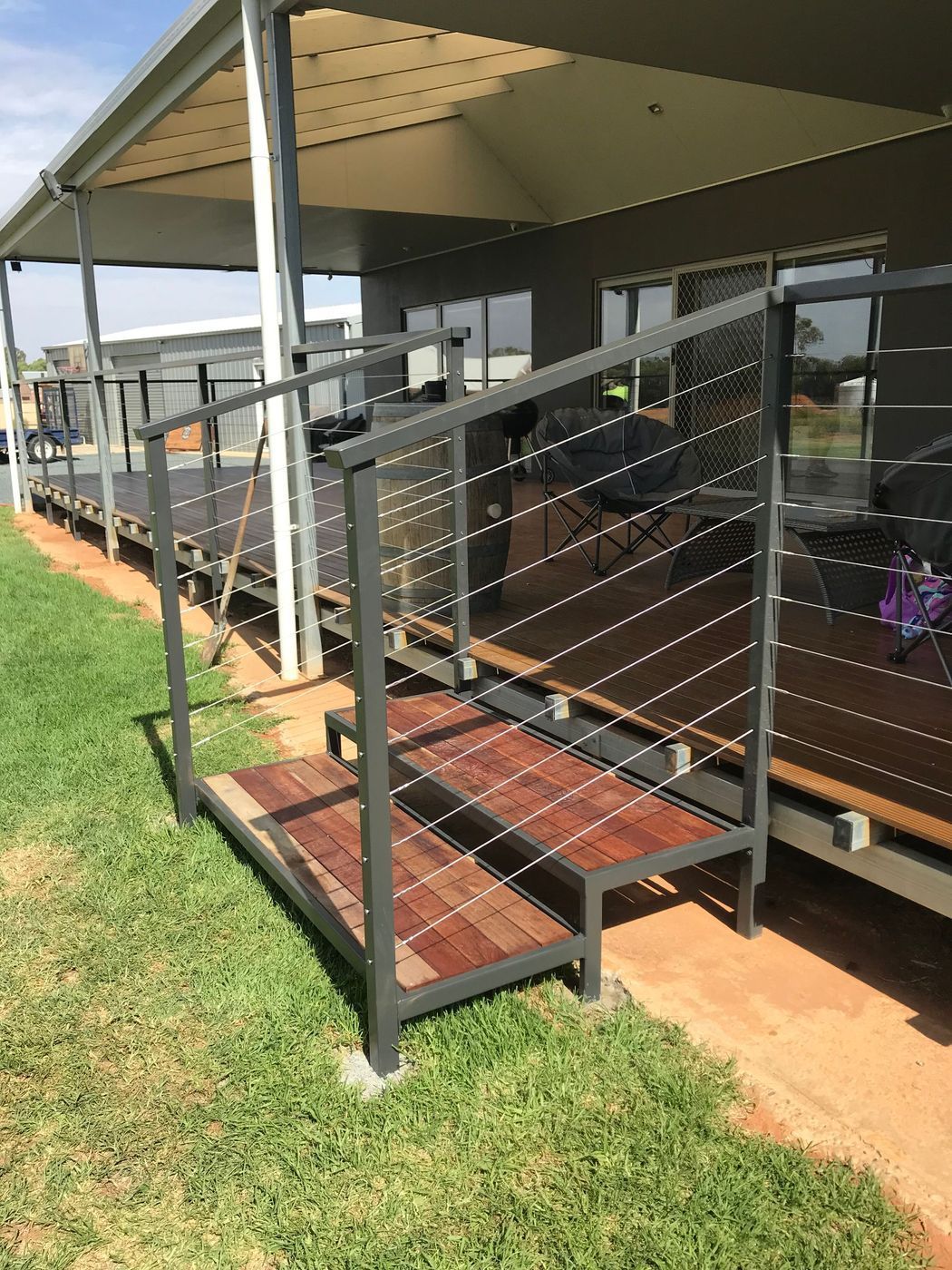 A metal railing with stairs leading up to a deck.