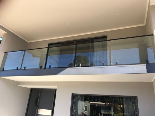 A balcony with a glass railing on the side of a building.