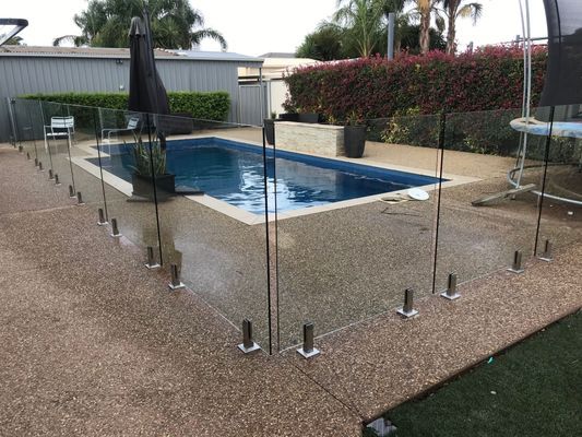 A swimming pool with a glass fence around it
