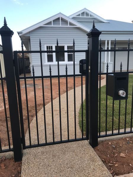 A black fence with a mailbox in front of a house