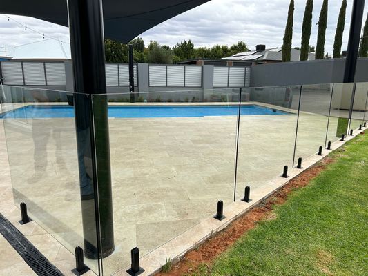 A swimming pool with a glass fence around it.