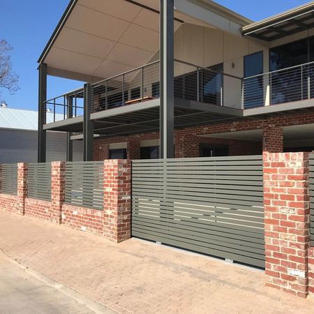 A large brick house with a fence around it