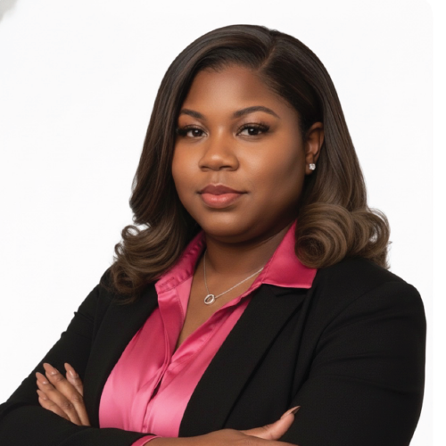Woman in black blazer and pink shirt, arms crossed, looking at the viewer.
