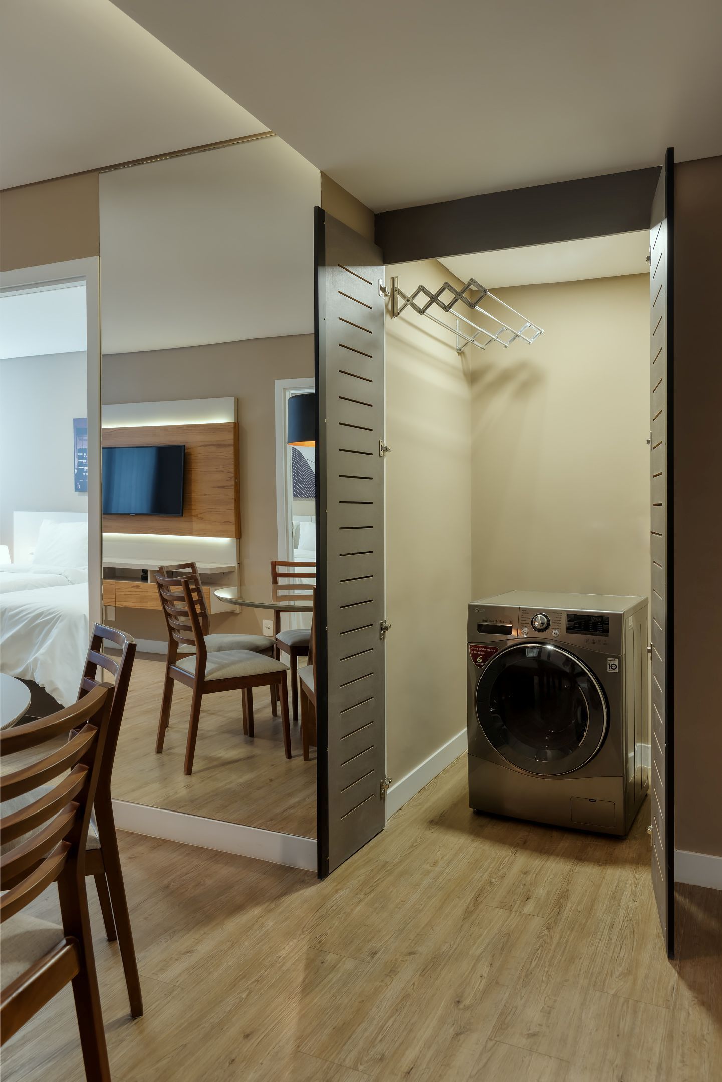 Uma máquina de lavar e uma secadora ficam em um armário em um quarto de hotel.