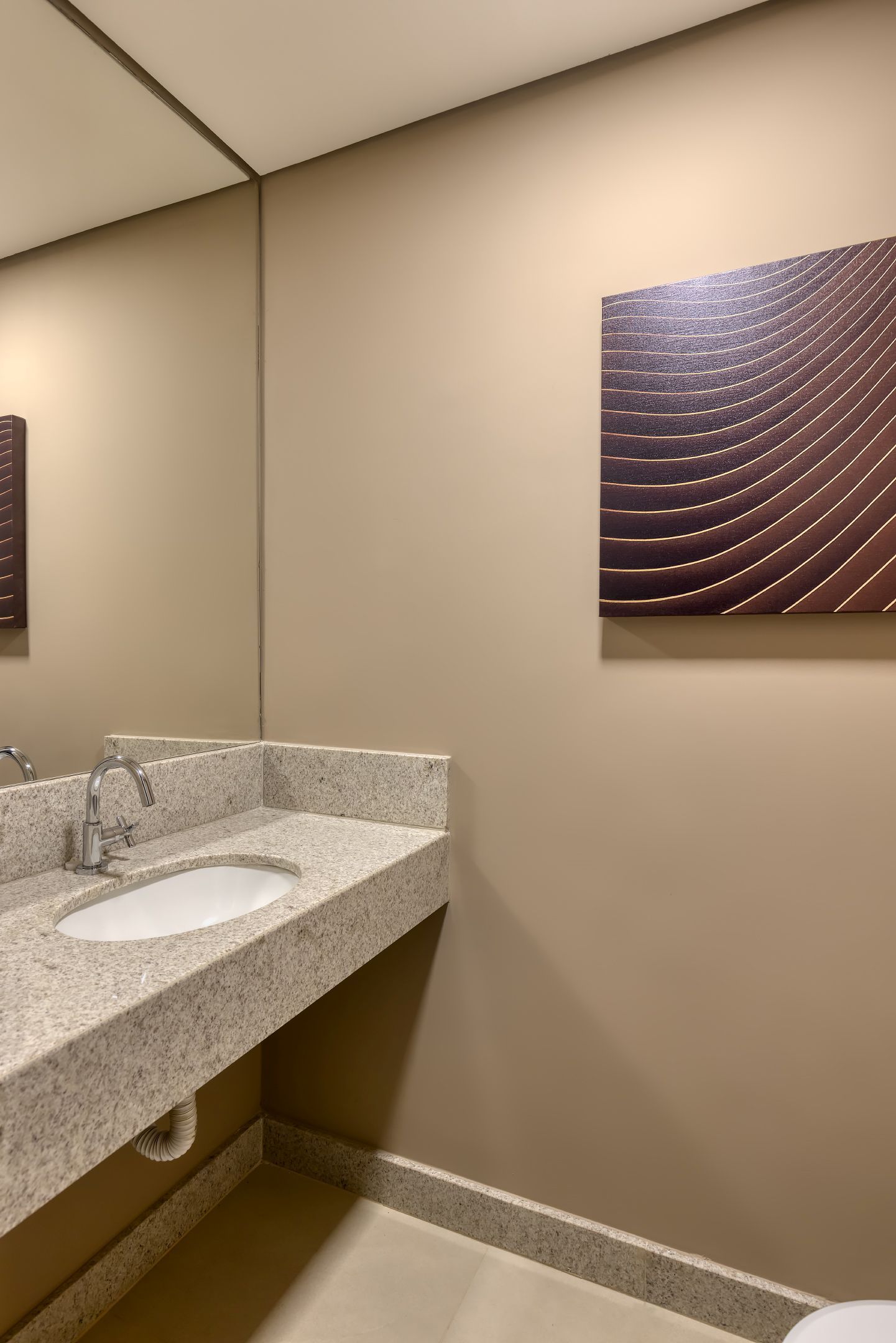 Um banheiro com pia, vaso sanitário e espelho.