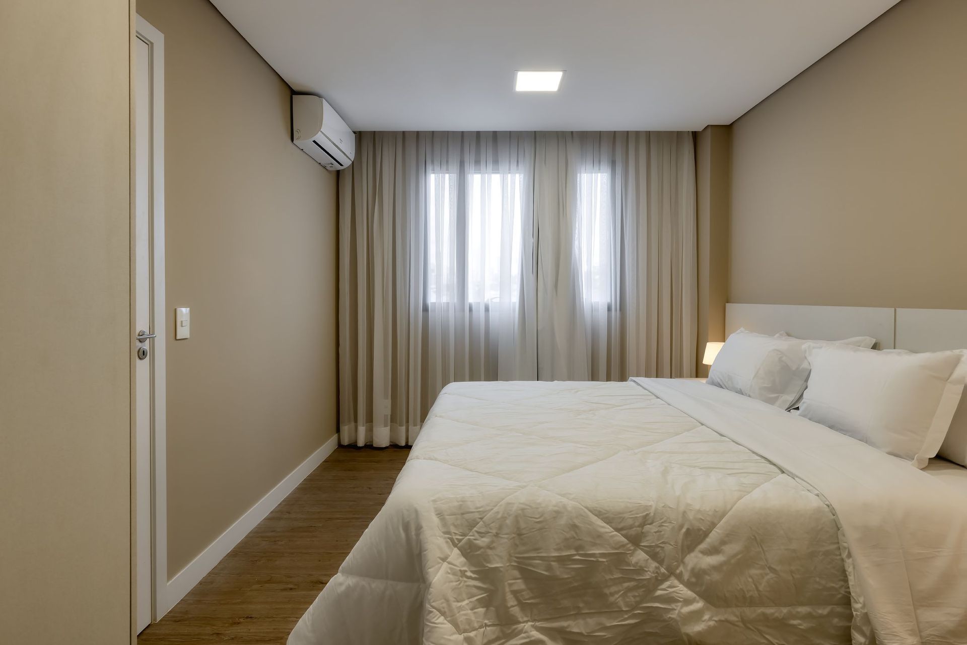 Um quarto com uma cama king size e uma janela.