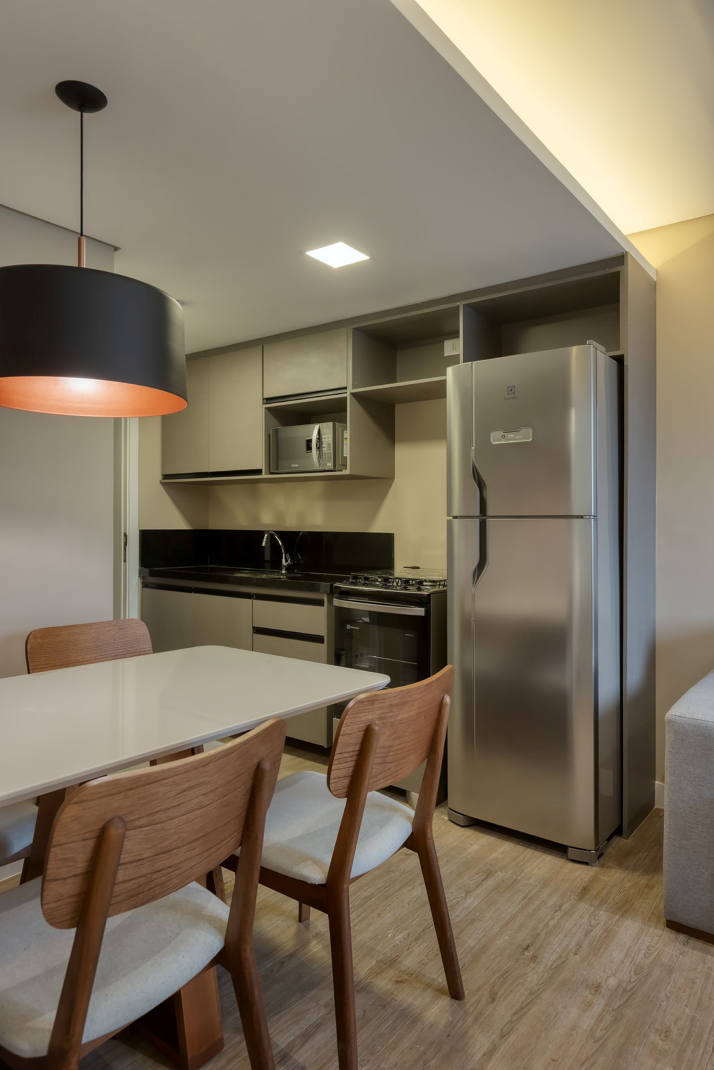 Uma cozinha com mesa e cadeiras e uma geladeira