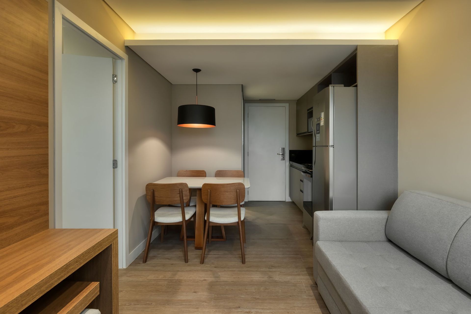 Uma sala de estar com um sofá, uma mesa e cadeiras