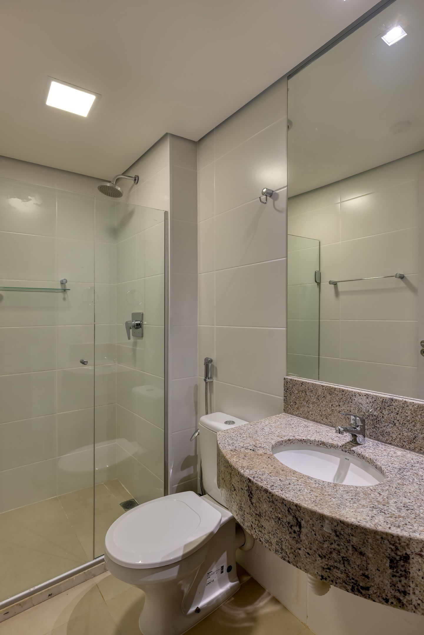 Um banheiro com vaso sanitário, pia e chuveiro.